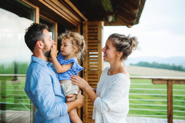 family-with-small-daughter-on-patio-of-wooden-cabi-2024-10-20-01-02-34-utc